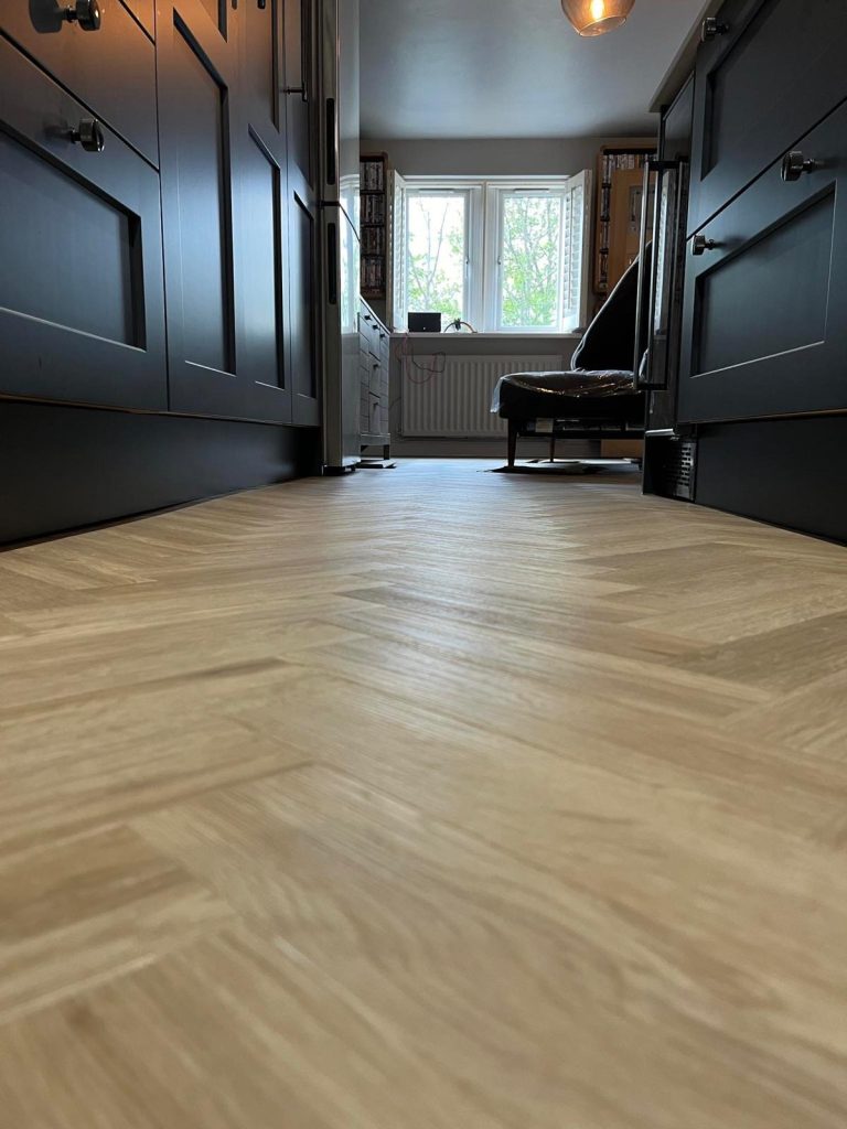 Elegant light wood LVT flooring in a modern home office with dark cabinetry